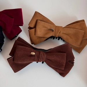Detailed close-up of velvet bow banana hair clips in dark brown, caramel, burgundy, and black