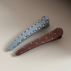 Detail of acetate hair clips with heart and polka dot prints in blue and brown contrast