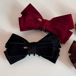 Detailed close-up of velvet bow hair clips with gold Love engraved metal tags