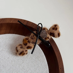 Detailansicht der Leoparden-Plüsch-Haarklammer mit schwarzer Schleife und Herz-Strass