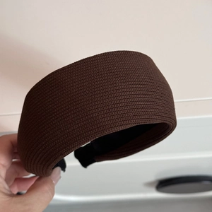 Detail of dark brown knitted striped wide headband showing texture and black inner lining