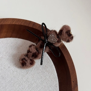 Detailansicht der Haarspange aus Leoparden-Webpelz mit schwarzer Schleife und Strass-Herz