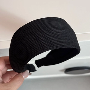 Close-up of black knitted texture fabric on a wide-brimmed padded headband