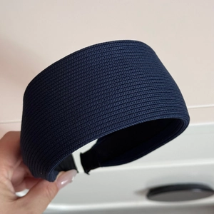 Detailed close-up showing the navy blue striped fabric texture of a wide knitted headband