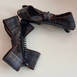 Détail de la pince à cheveux avec nœud en tissu écossais et peigne en plastique noir