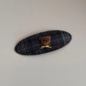 Détail de la pince à cheveux en tissu à carreaux bleu marine avec motif ours floqué