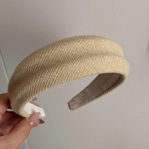 Detailed macro view of beige knitted fabric texture on thick padded retro headband