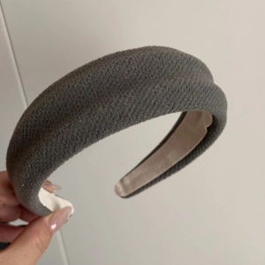 Detail view of grey thick sponge headband with textured fabric for high skull top effect