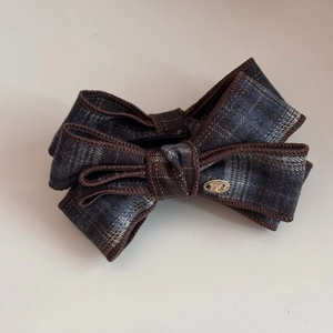 Vue détaillée du nœud papillon vintage à carreaux en tissu bleu foncé et marron élégant