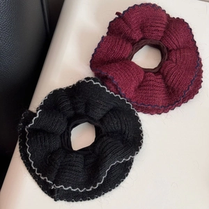 Dettaglio di elastici in maglia bordeaux e neri con trama di cuciture a contrasto