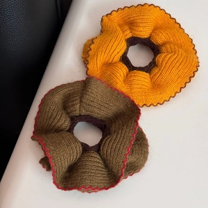 Dettaglio di elastici in maglia con trama intrecciata arancio e tortora e bordi a onde