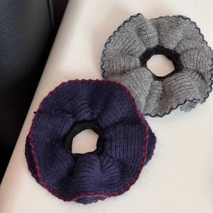 Vista dettagliata di elastici per capelli in maglia con bordi ondulati in viola e grigio