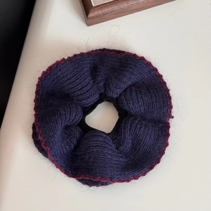 Dettaglio di elastico per capelli in maglia viola scuro con bordi a onde rosse