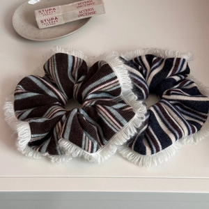 Detailed close-up of large striped knit hair scrunchies with elegant lace trim