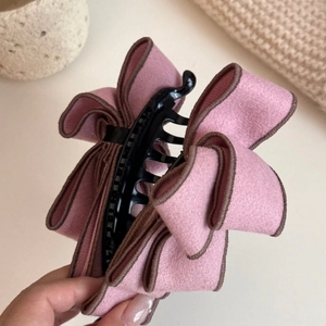 Detail of pink bow banana clip with layered fabric and fine brown edge stitching