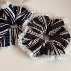 Detailed view of striped hair scrunchies with white eyelash lace trim and knit texture