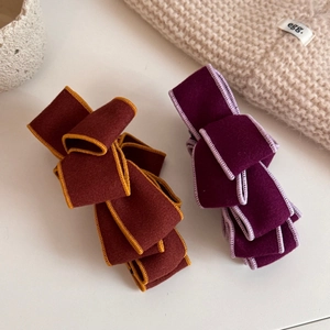 Detail of premium velvet bow hair clips with contrasting stitched edges for autumn style