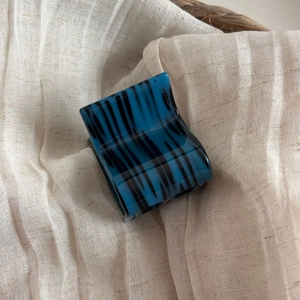 Detailed macro view of the small square blue acetate hair claw clip with black marbled pattern