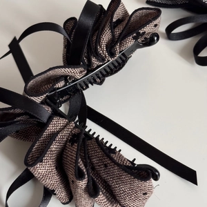 Close-up of vintage brown plaid fabric and black ribbon layers on the banana hair clip