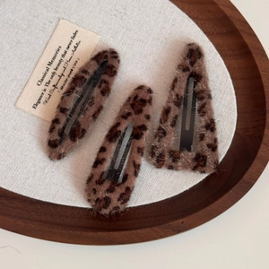 Leopard print plush hair clips set in vintage aesthetic on dark wooden tray