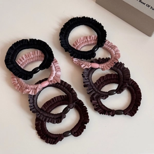 Detailed view of 8-piece pleated elastic hair scrunchies with oval beads in neutral colors