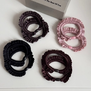 Detailed macro view of 8-pack pleated satin hair scrunchies with resin oval buckle accents