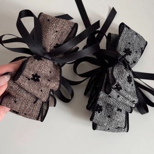 Close-up of dual-color tweed bow hair clips with velvet flower accents and ribbon details