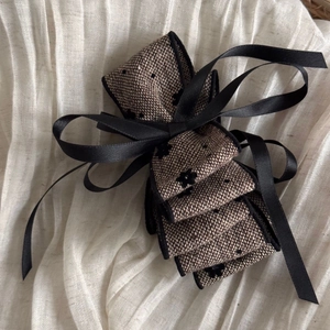 Detail of vintage fabric bow hair clip with black floral print and satin ribbon trim