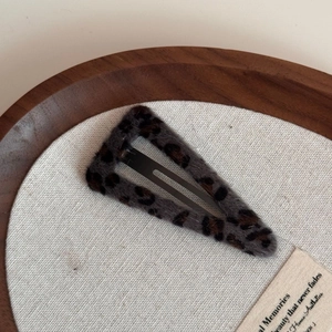 Detail showing plush leopard print hair clip with a sturdy black metal duckbill grip
