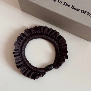Detail of ruffle hair scrunchie in deep coffee satin with decorative oval bead buckle