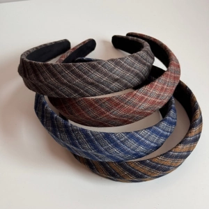 Detailed view of plaid fabric headbands in grey, red, blue and yellow textured weaving