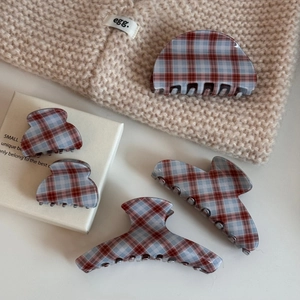 Detail view of five assorted red and blue plaid acetate hair claws in various sizes