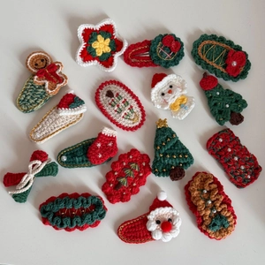 Vue à plat de quinze barrettes de Noël variées en crochet faites main sur fond blanc