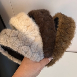 Detail of four fuzzy braided headbands in grey, beige, and brown autumn colors