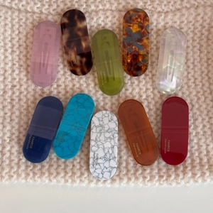 Set of 10 oval acetate hair clips with tortoise shell and marble patterns on knit fabric