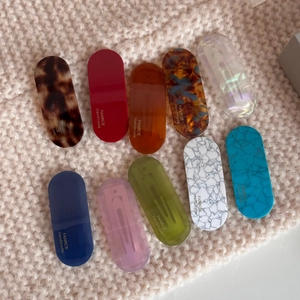 Close-up of assorted acetate hair clips with diverse patterns and silver metal base