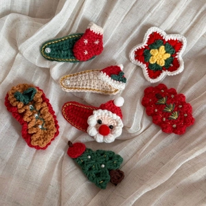 Détail de sept barrettes de Noël faites à la main au crochet avec des motifs tricotés