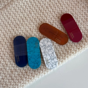 Five-piece set of oval acetate hair clips in marble and amber patterns on beige fabric