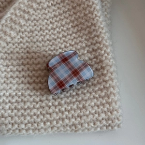 Close-up of vintage plaid acetate hair claw with red-brown and blue checkered pattern