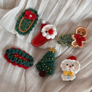 Détail de six barrettes de Noël faites à la main au crochet avec motifs en tricot
