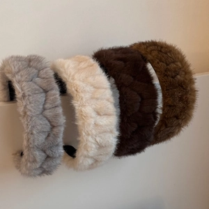 Detail showing plush faux fur headbands with woven pleated texture in multiple colors