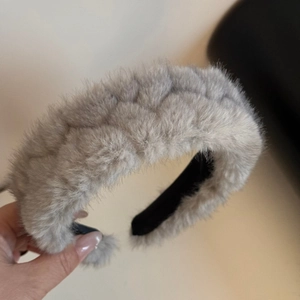 Detail of light grey plush headband featuring woven quilted texture and padded design