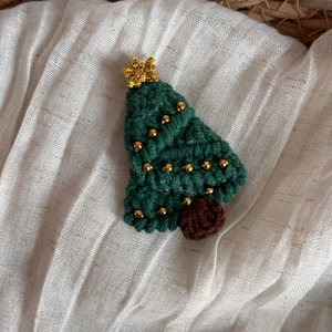 Détail de la pince à cheveux sapin de Noël en tricot fait main avec perles dorées et étoile