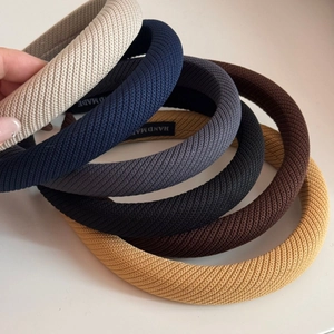 Gros plan sur six couleurs de serre-tête tricotés épais avec des étiquettes faites à la main