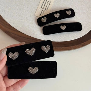 Détails de barrettes en velours noir ornées de motifs de cœurs en strass élégants
