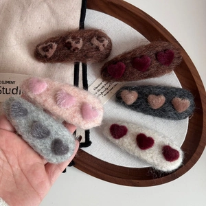 Close-up of wool felt hair clips featuring 3D heart patterns in six various colors