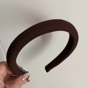 Gros plan sur le serre-tête en éponge tricotée marron café avec texture de sergé