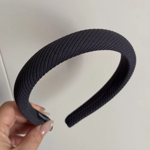 Détail d'un serre-tête en tricot gris foncé avec texture sergé et rembourrage épais