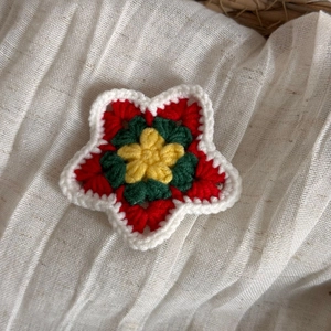 Détail de la pince à cheveux étoile au crochet avec motifs tricotés colorés et textures