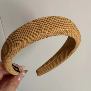 Détail d'un serre-tête épais en sergé jaune avec une étiquette faite à la main